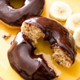 baked banana donuts with chocolate glaze on a yellow plate