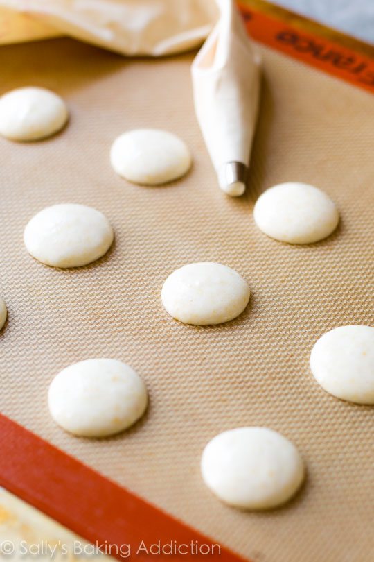 macaron shells on a silpat baking mat