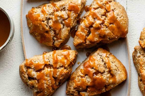 apple scones with caramel sauce drizzled on top.