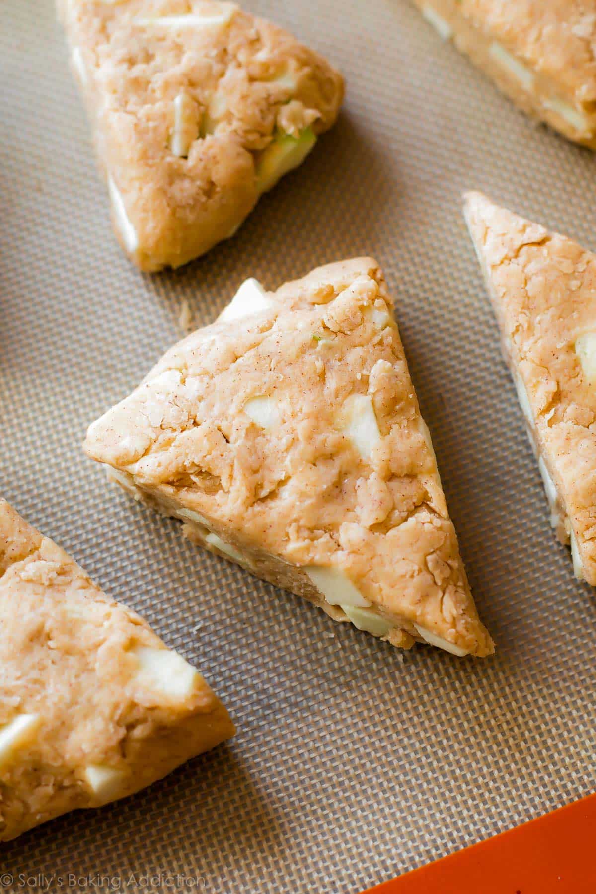 apple cinnamon scone dough cut into triangles on a baking sheet