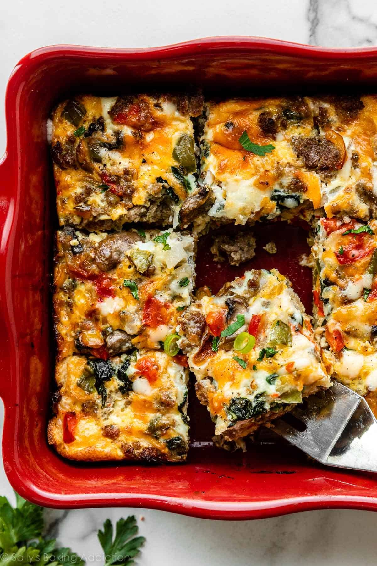 overhead photo of egg and sausage breakfast casserole in red baking dish.