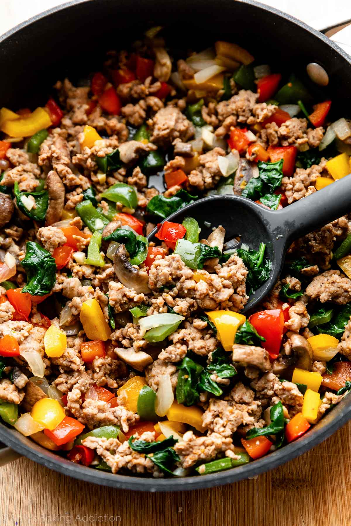 cooked sausage, mushrooms, bell peppers, and spinach in large skillet.