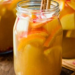 apple cider sangria in a glass with cinnamon sticks