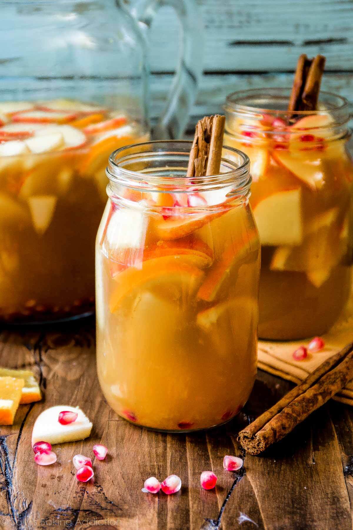 apple cider sangria in glass jars with cinnamon sticks