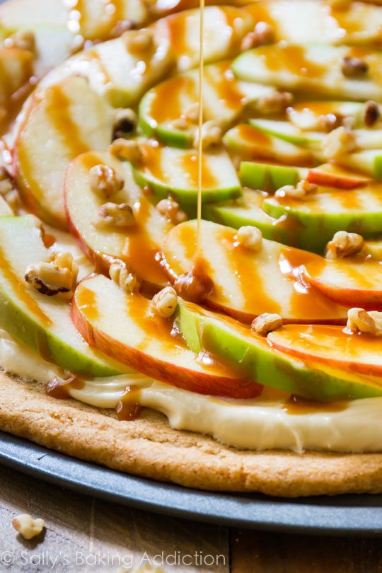 drizzling caramel sauce onto apple dessert pizza
