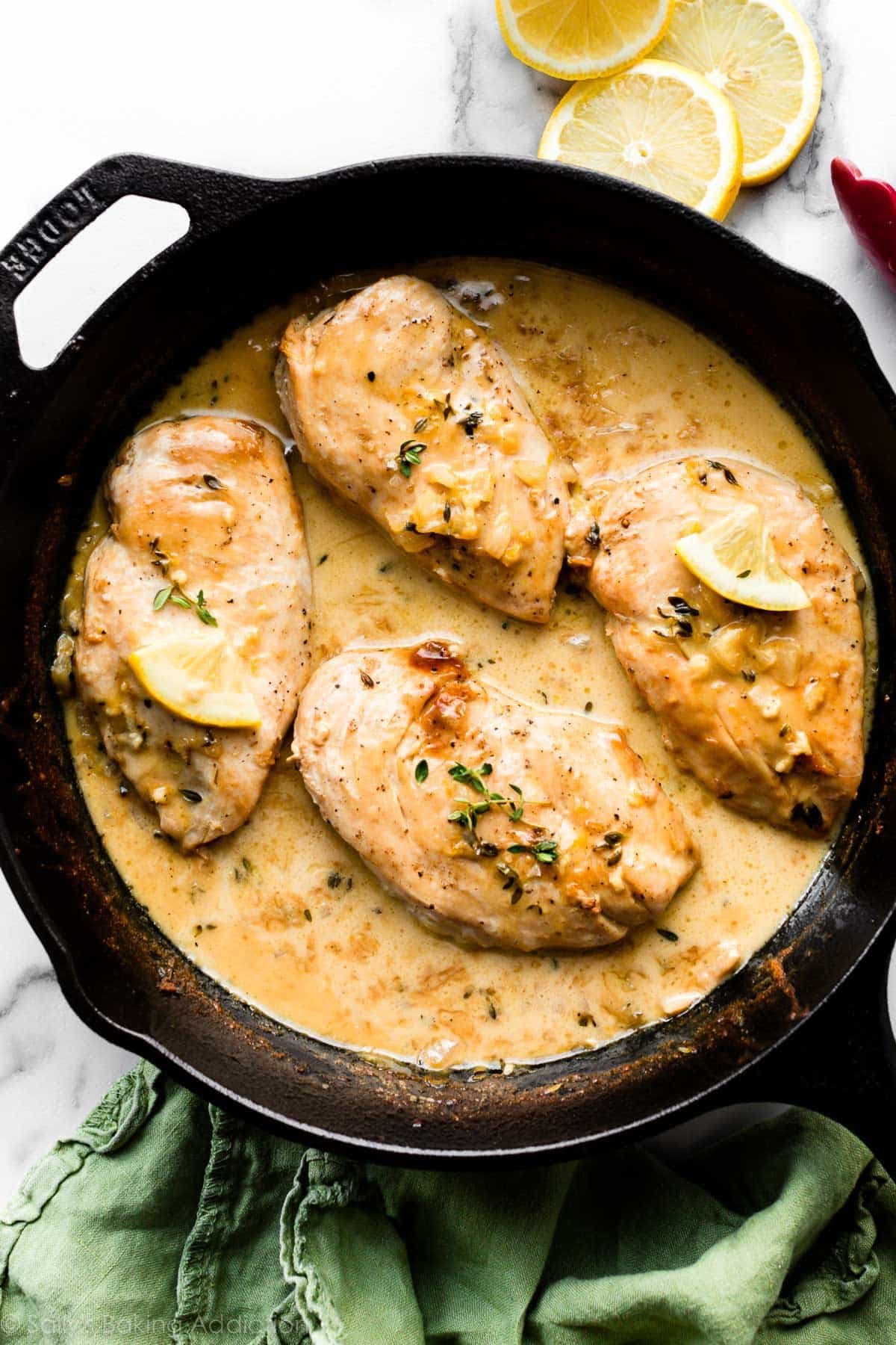 Chicken breasts in a lemon and thyme cream sauce in a cast iron skillet
