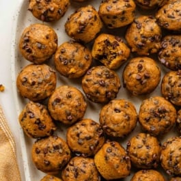 mini pumpkin chocolate chip muffins on serving plate.