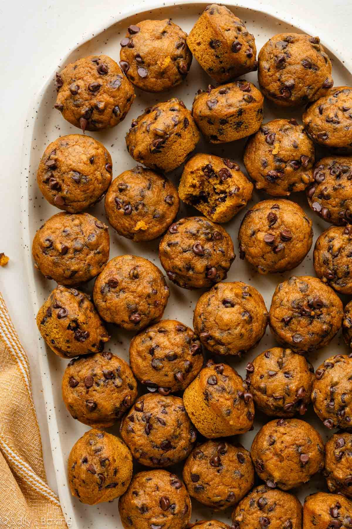 mini pumpkin chocolate chip muffins on serving plate.