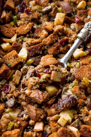 zoomed image of herbed sausage and apple stuffing with a serving spoon