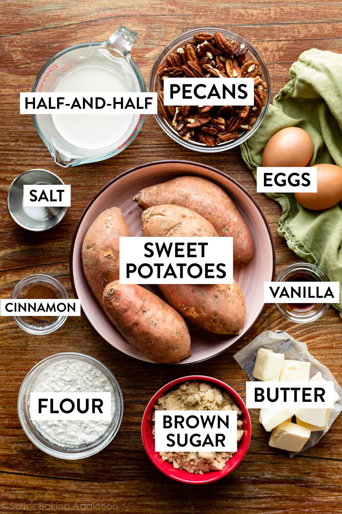 ingredients on a wooden background including pecans, sweet potatoes, eggs, butter, brown sugar and more.