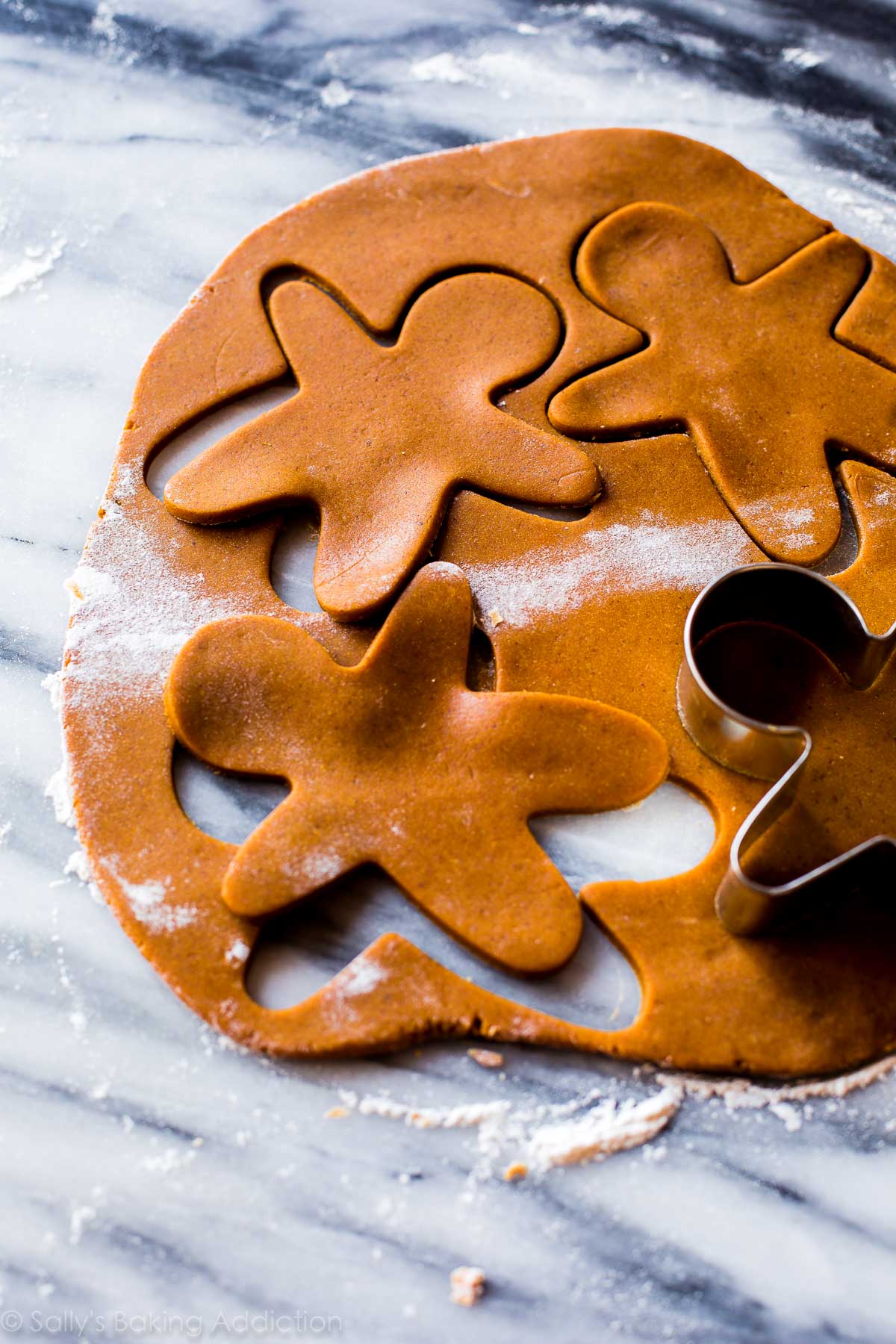 rolled out gingerbread cookie dough with a gingerbread man cookie cutter