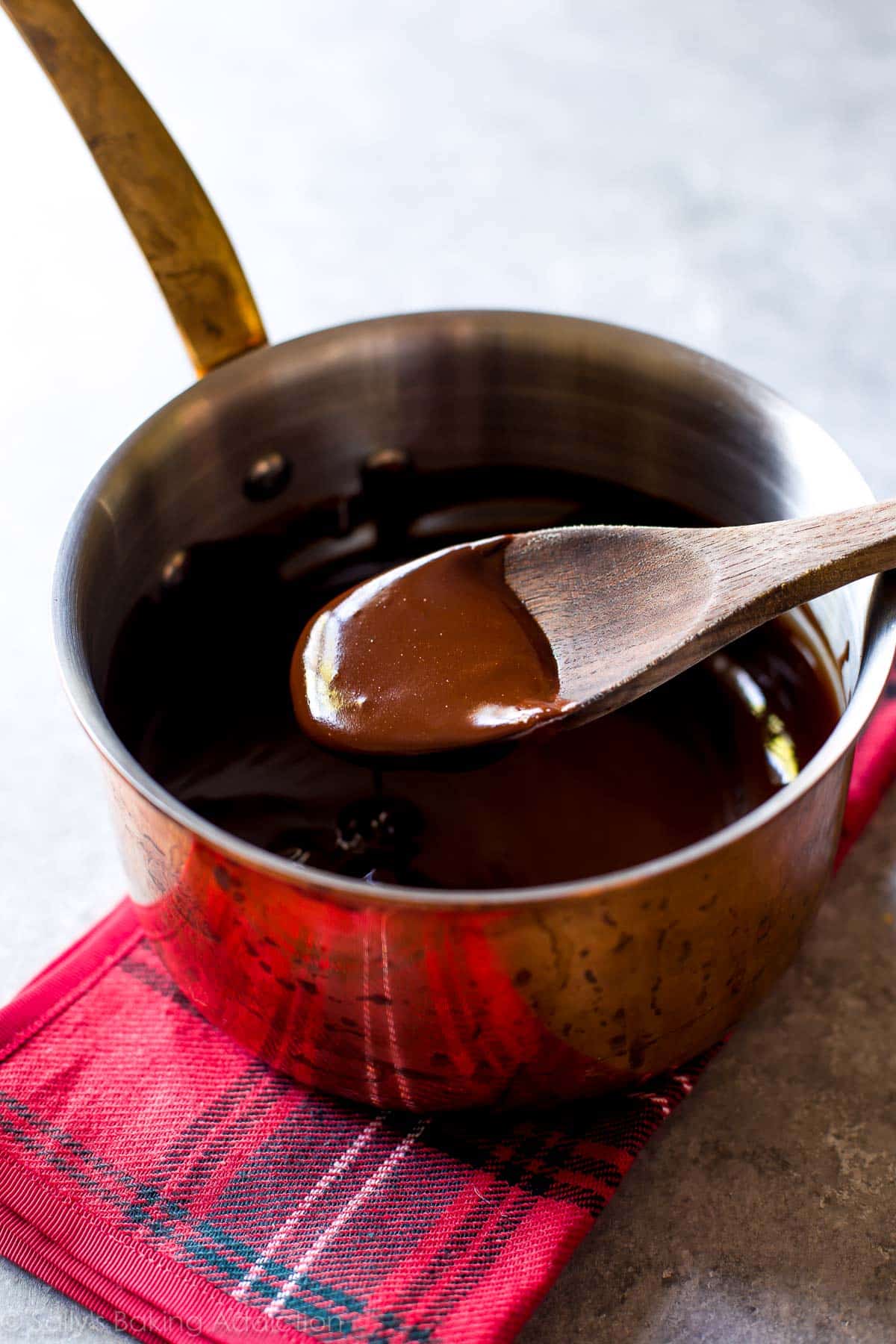 melted butter and chocolate in a copper saucepan with a wood spoon