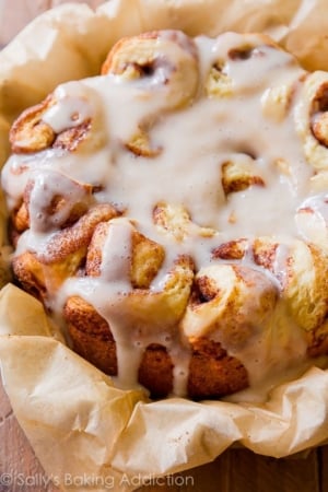 slow cooker cinnamon rolls with maple icing on parchment paper