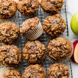 12 healthy apple muffins on wire cooling rack with coarse sugar sprinkled on top of each.
