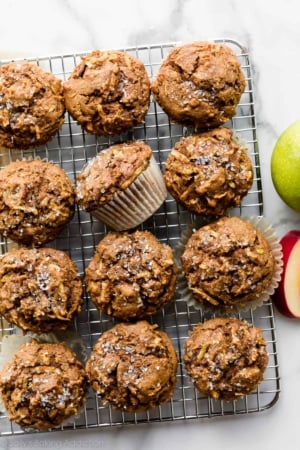 12 healthy apple muffins on wire cooling rack with coarse sugar sprinkled on top of each.