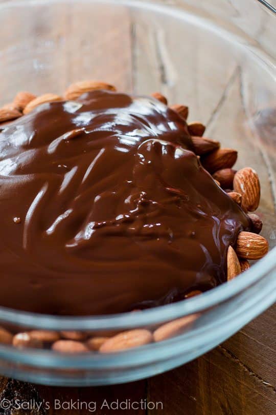 almonds and melted chocolate in a glass bowl