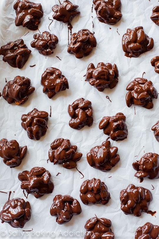 dark chocolate almond clusters on parchment paper before they're set up