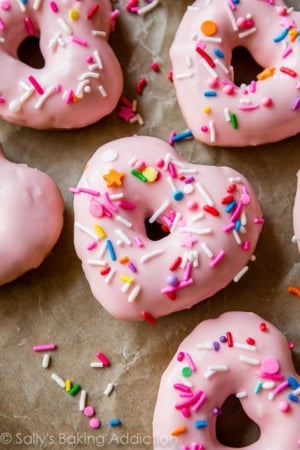 heart shaped donuts topped with pink glaze and sprinkles