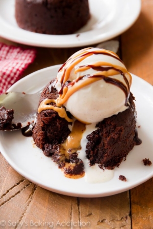 chocolate peanut butter lava cake with a scoop of ice cream on top on a white plate with a spoon