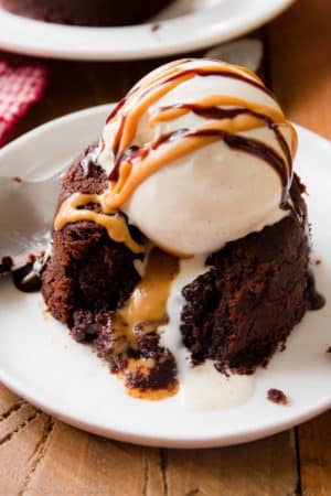 peanut butter chocolate lava cake on a white plate with a scoop of vanilla ice cream on top.