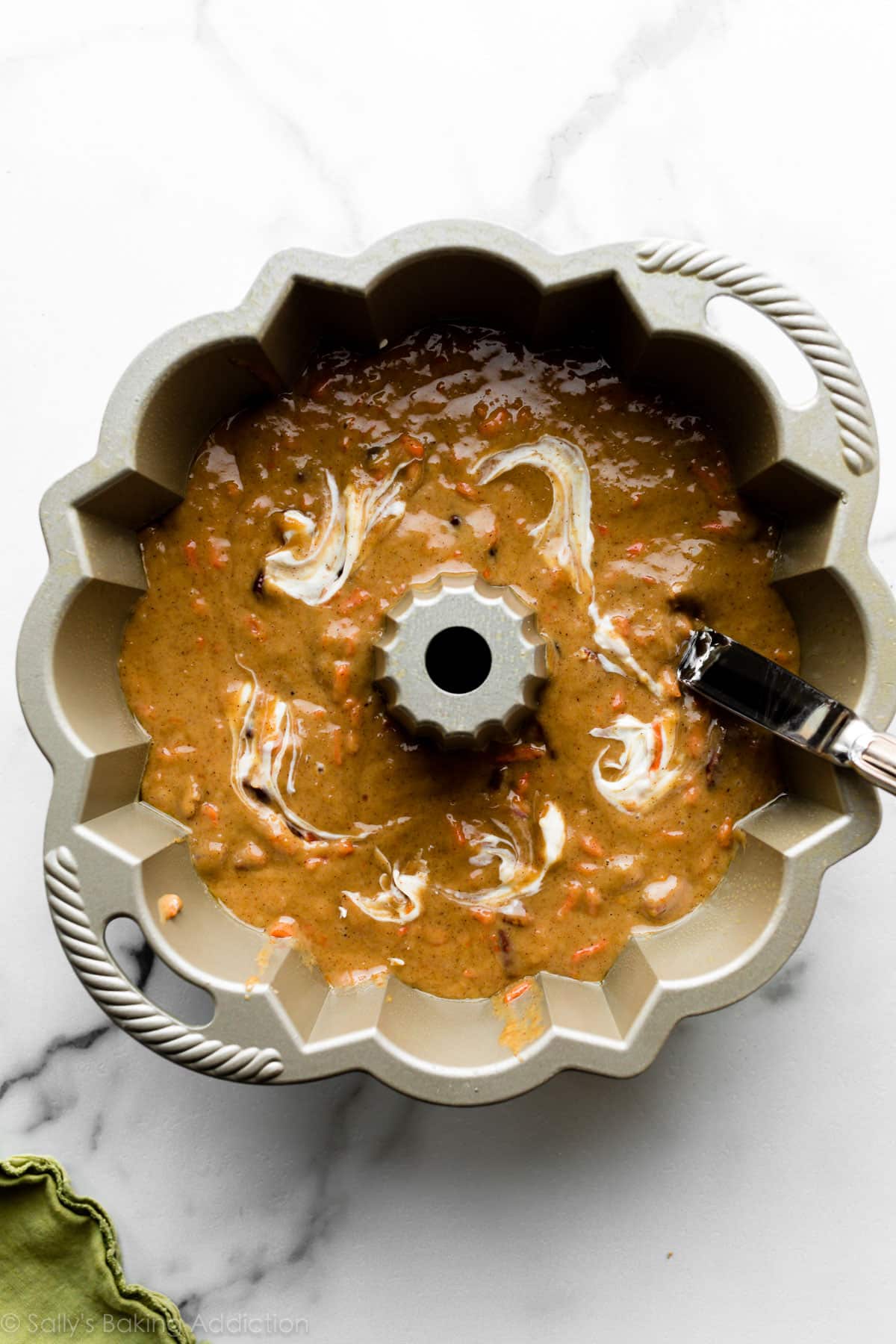 cream cheese mixture swirled with carrot cake batter in a Nordic Ware Anniversary Bundt pan