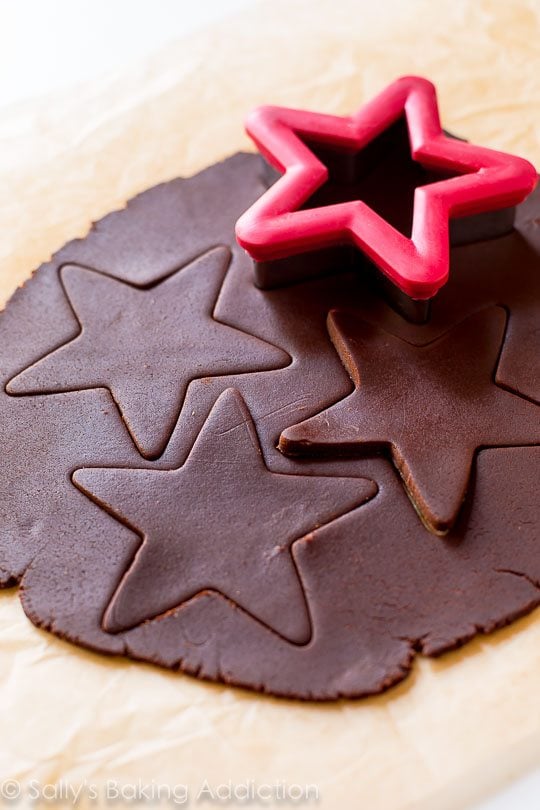 chocolate sugar cookie dough rolled out with a star cookie cutter