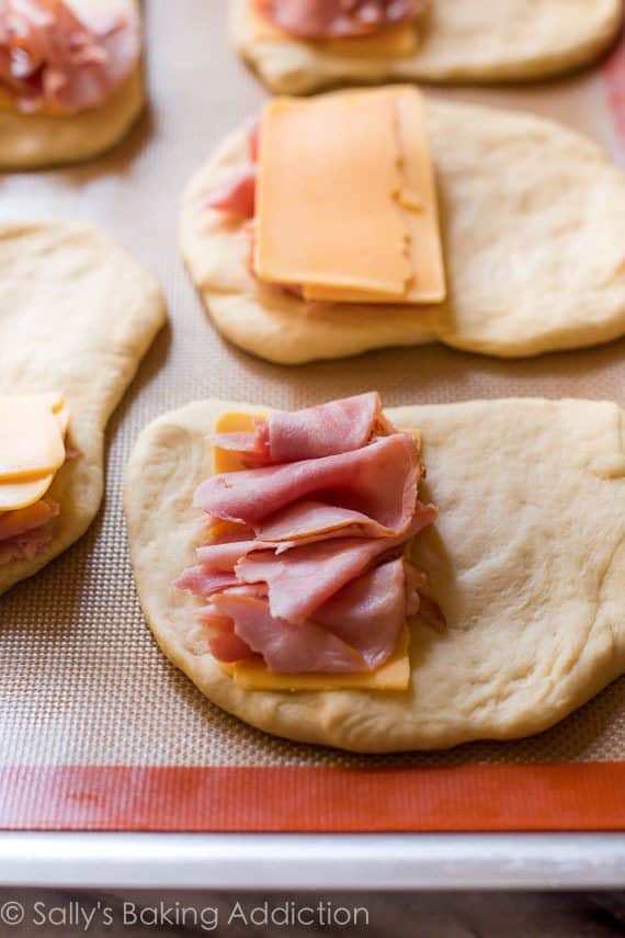 ham and cheese on top of pieces of dough for ham and cheese pockets