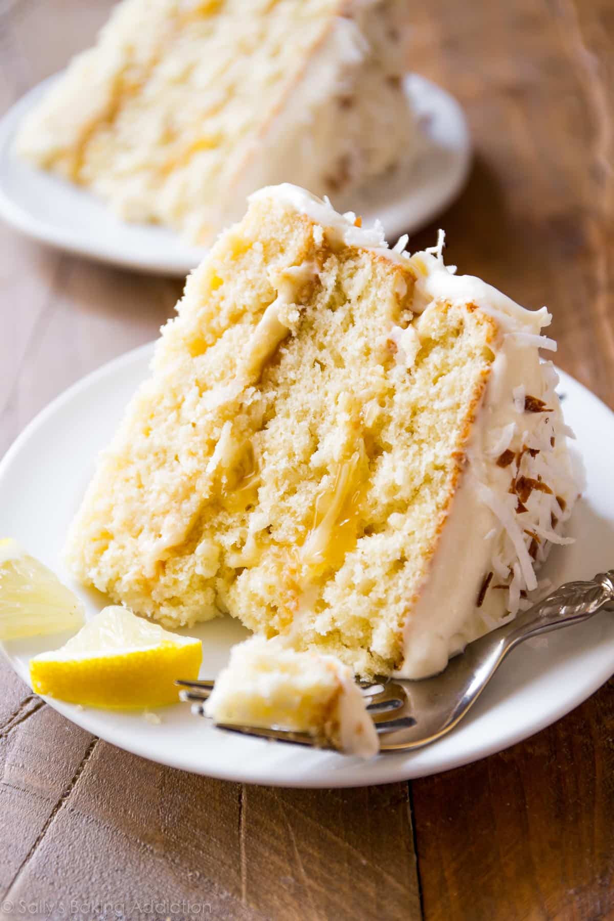slices of lemon coconut cake on a white plates with a fork