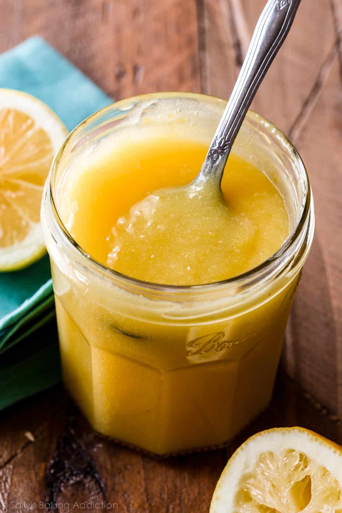 lemon curd in a glass jar with a spoon