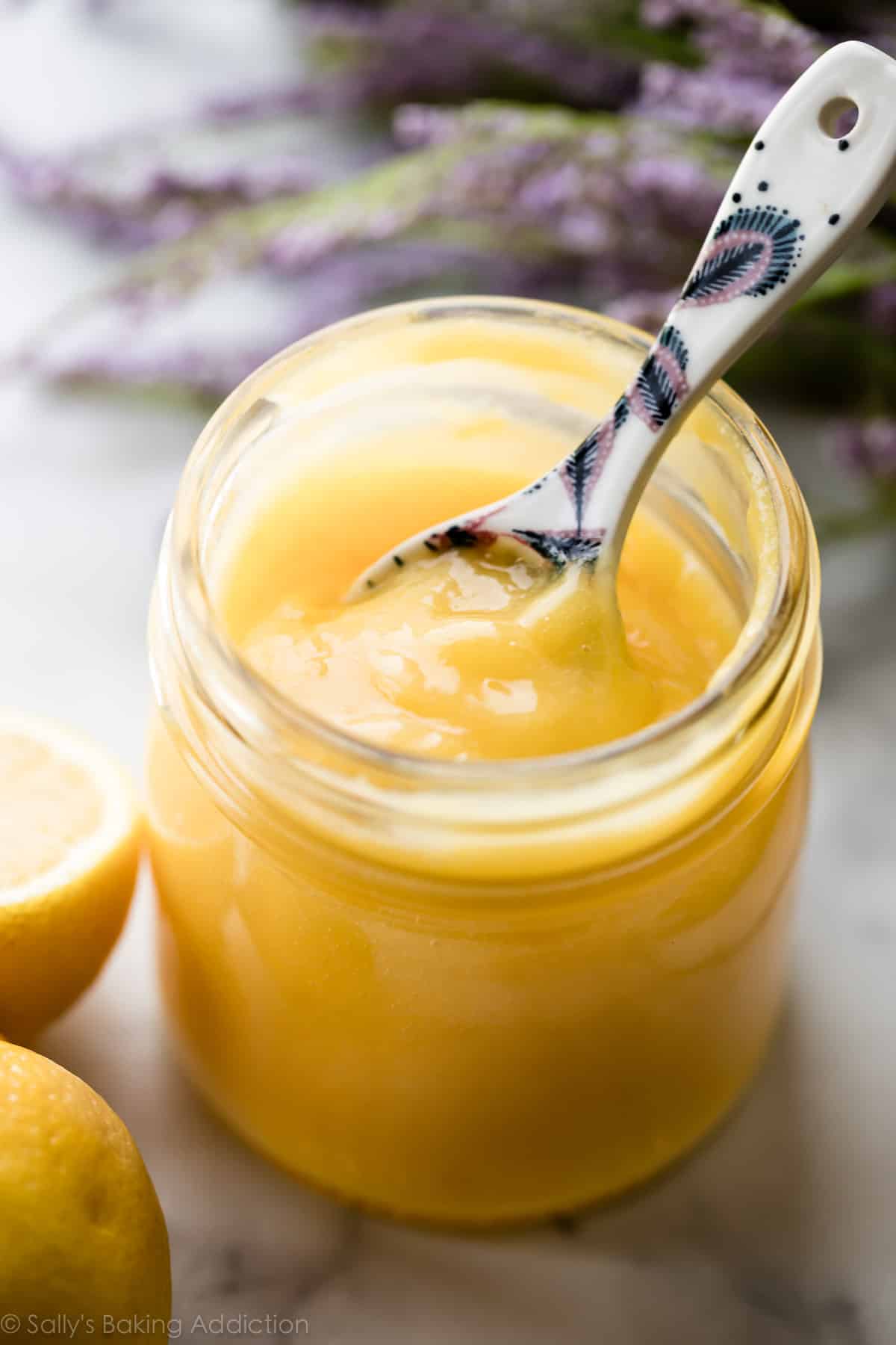 Lemon curd in a glass jar with spoon