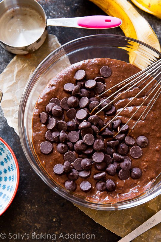 whole wheat double chocolate banana muffins batter in a glass bowl with a whisk