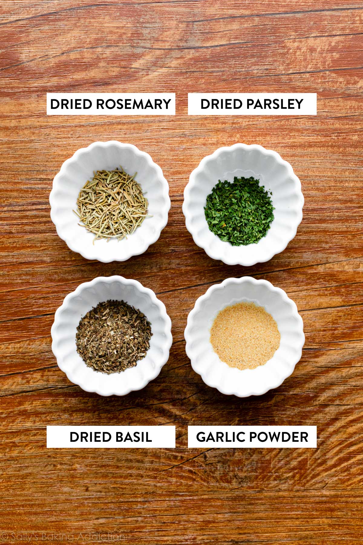 dried herbs and garlic powder in small white bowls