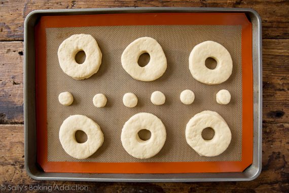 doughnuts and doughnut holes on a silpat baking mat