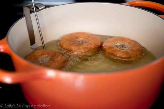 doughnuts frying in a pot of oil on the stovetop