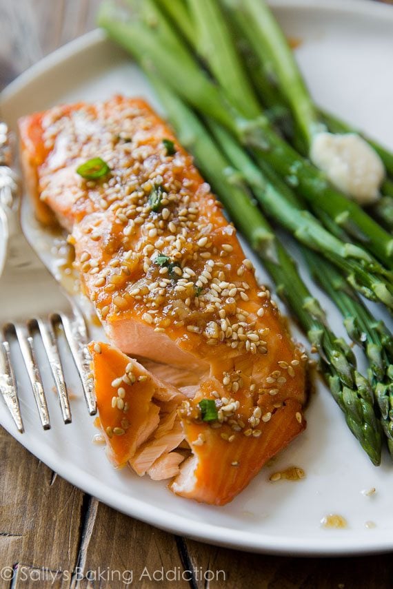 maple sesame salmon on a white plate with asparagus