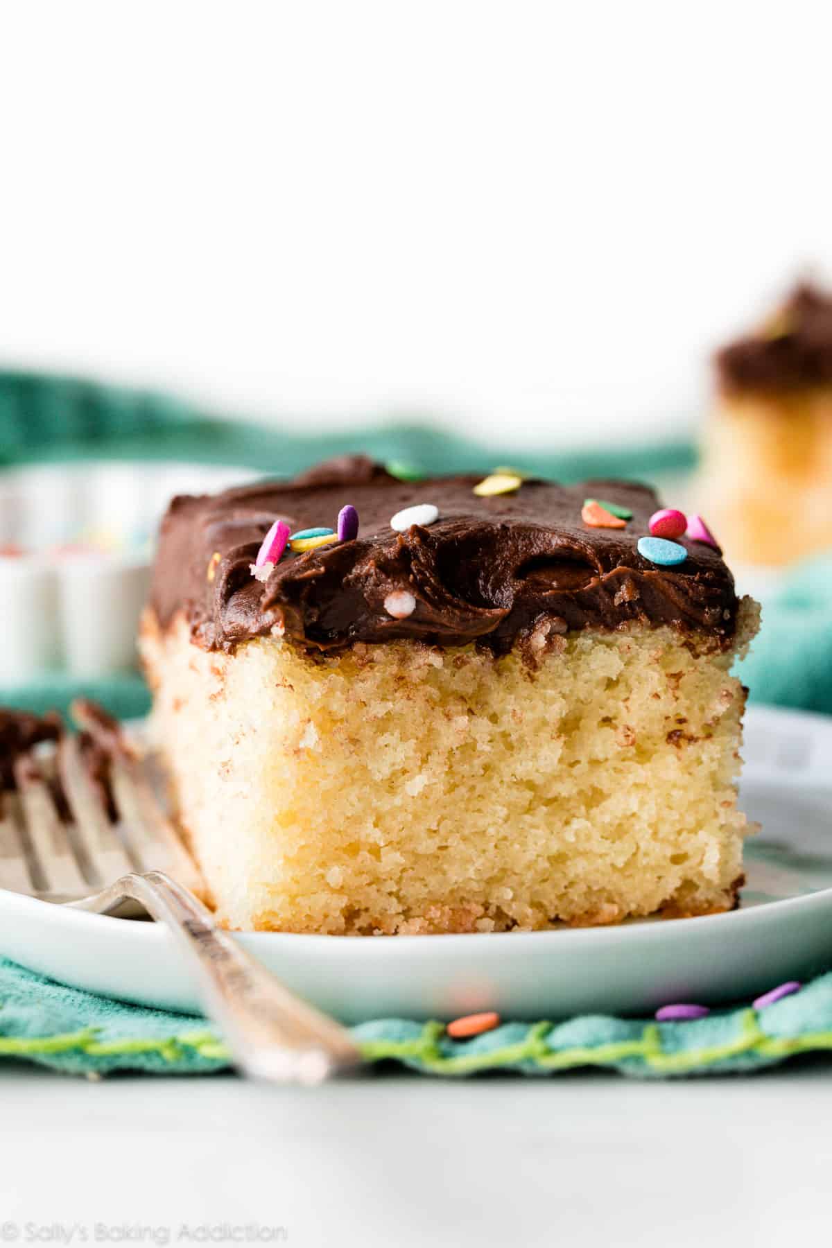 slice of yellow sheet cake with chocolate frosting and sprinkles