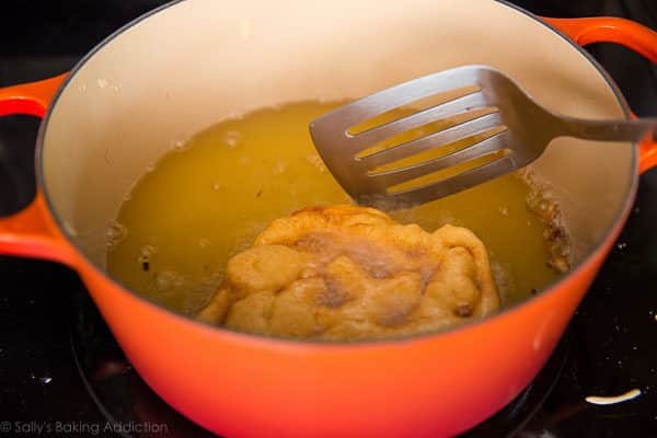 funnel cake frying in a pot of oil on the stove