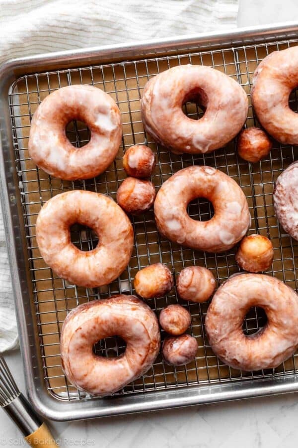 glazed doughnuts on wire cooling rack on top of baking sheet.
