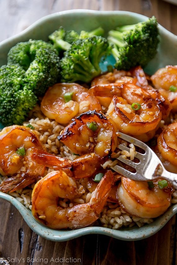 Honey garlic shrimp in a bowl with rice and broccoli with a fork