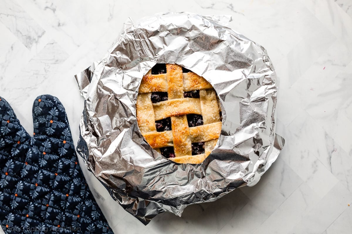 aluminum foil pie crust shield over partially baked pie.