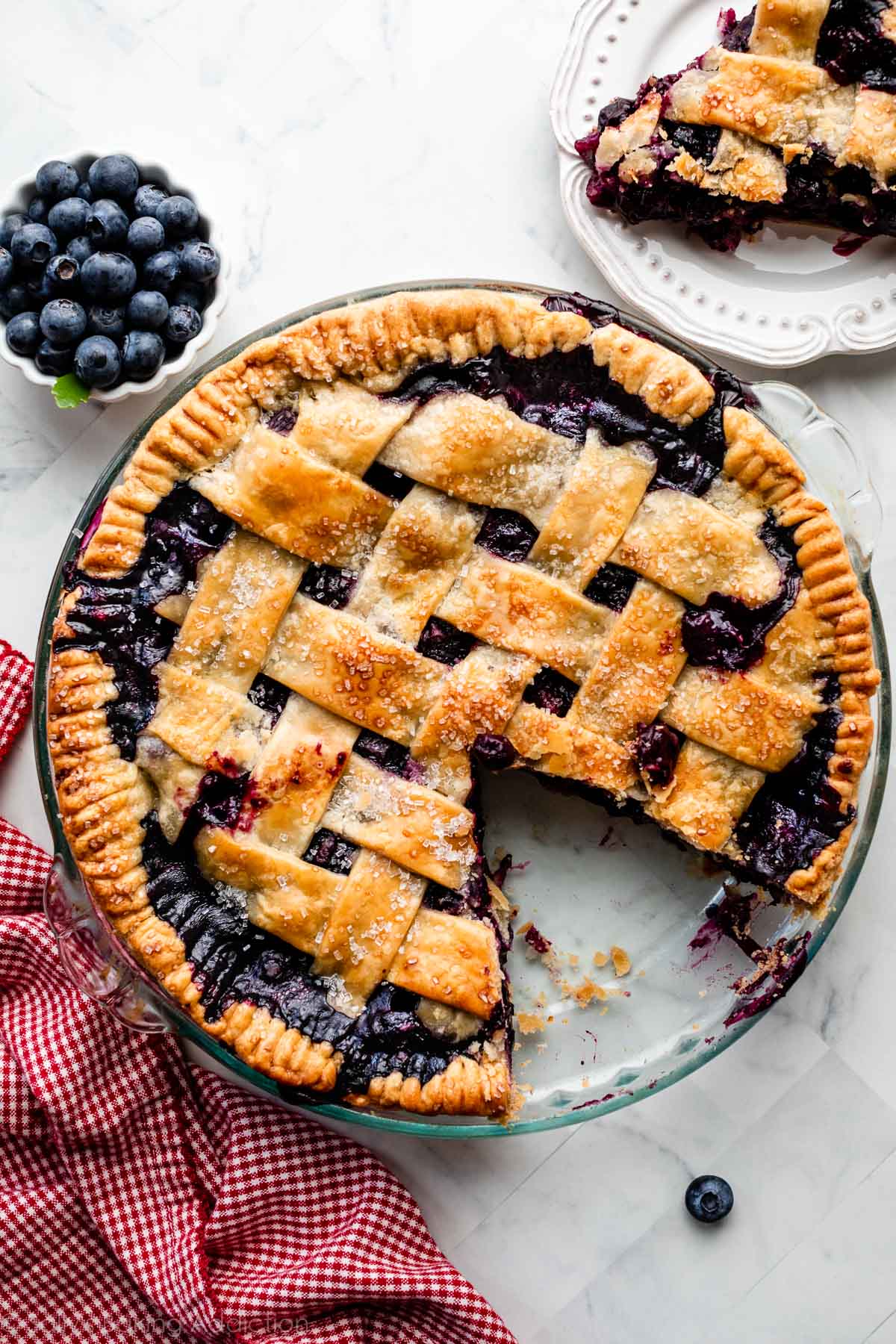 blueberry pie with lattice top with slice taken out.