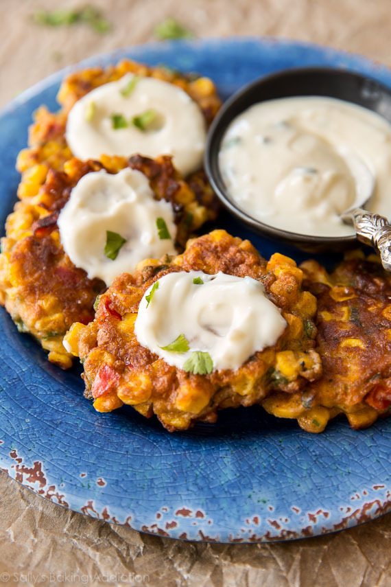 corn fritters with yogurt dip on a blue plate