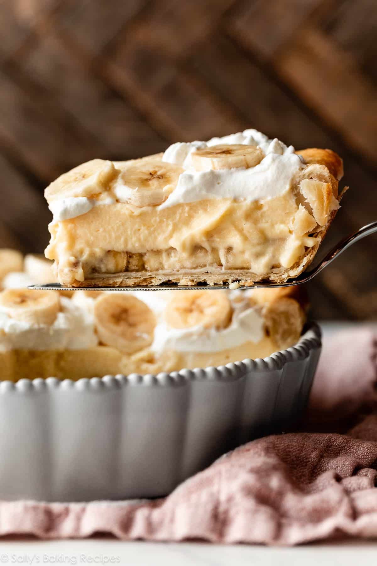 slice of banana cream pie being removed from pie dish.