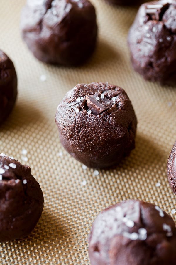 dark chocolate cookie dough balls sprinkled with sea salt on a silpat baking mat