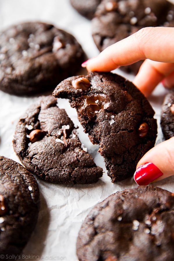 hand holding half of a salted dark chocolate cookie