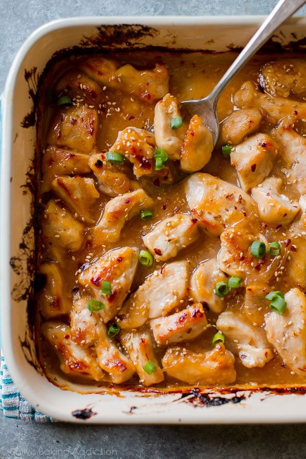overhead image of sweet chili chicken in a baking dish with a serving spoon