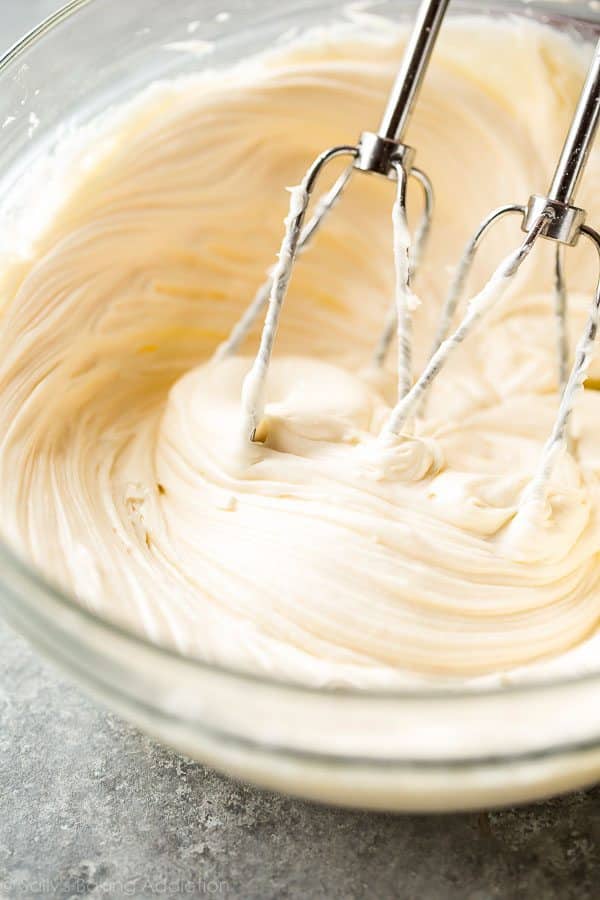 Cream cheese frosting in glass bowl with hand mixer
