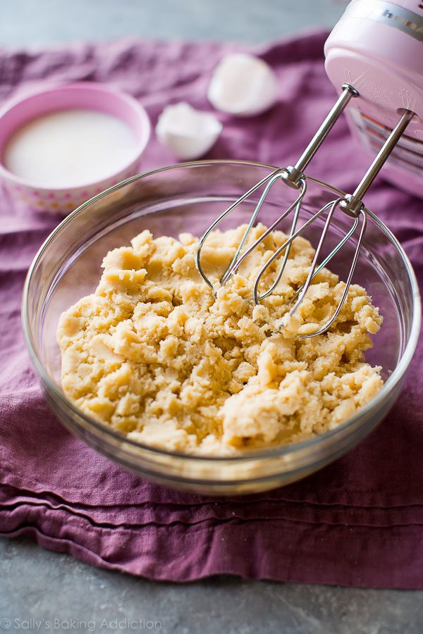 cream cheese sugar cookie dough in a glass bowl with a hand mixer