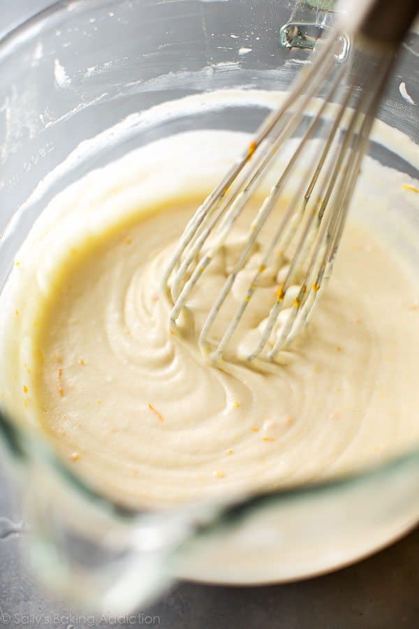 mimosa cupcake batter in a glass bowl with a whisk