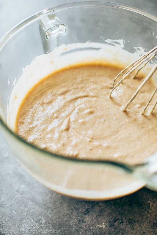 banana cake batter in a glass bowl with a whisk